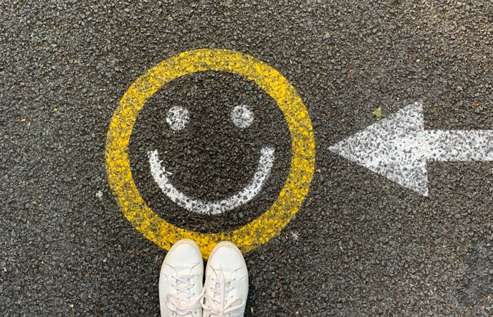 Skor på målad glad figur på asfalt