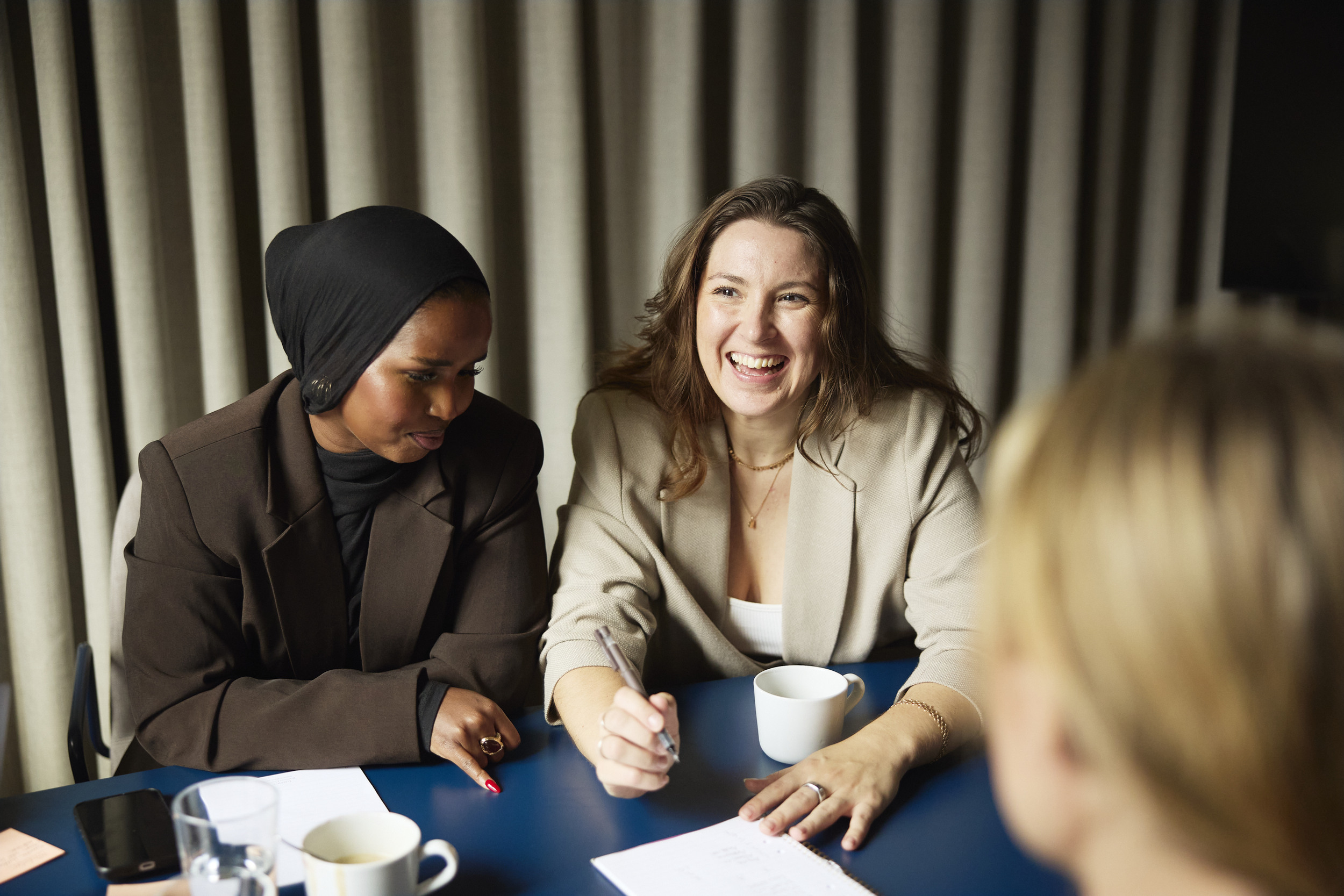 Två kvinnor sitter vid ett bord och samtalar.