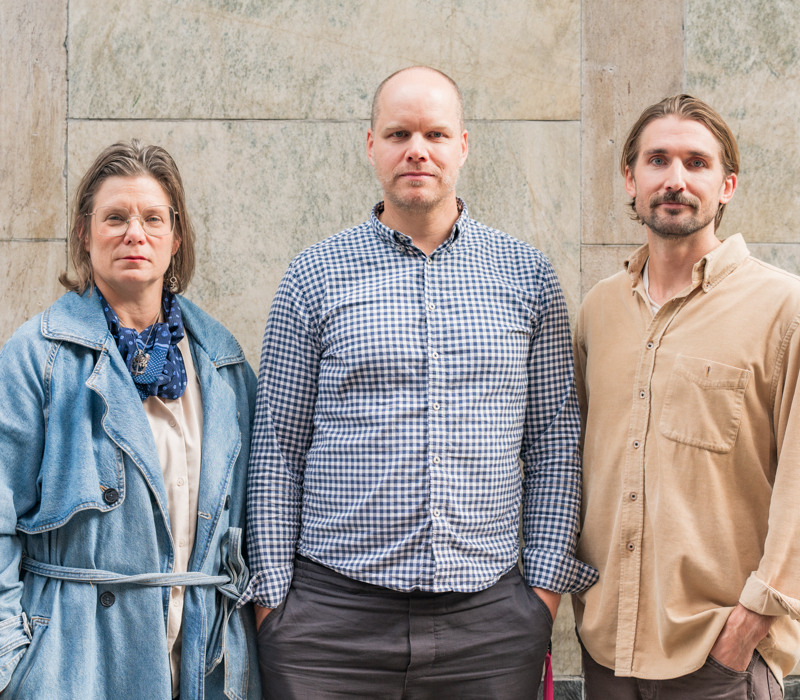 En grupp på tre personer som står bredvid varandra.